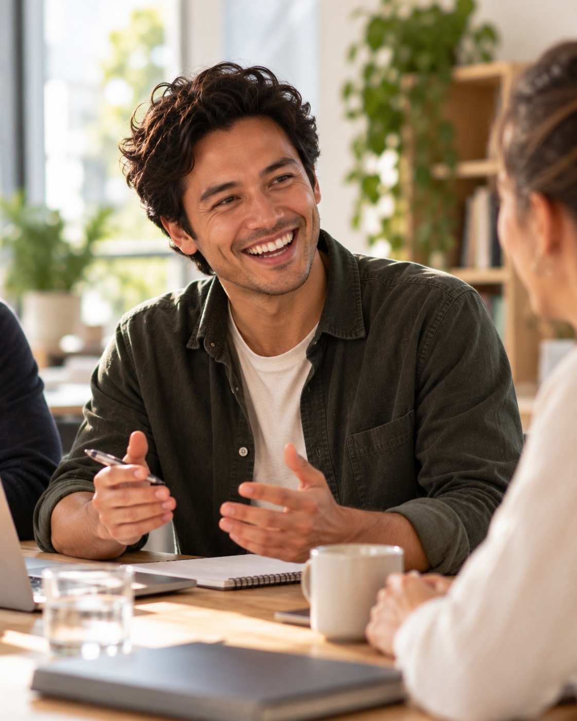A young man talking with his hands at a meeting table